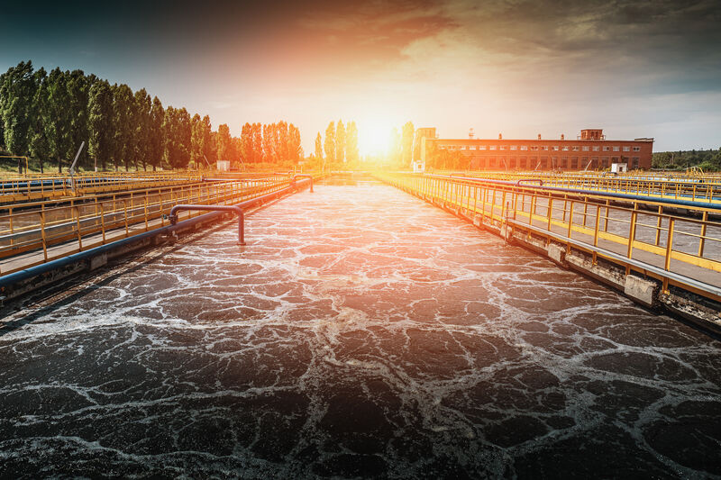 Eine gefüllte Kläranlage mit Wasserbewegung im Sonnenuntergang.